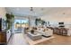 Bright, open-concept living room featuring a modern sofa and a seamless flow to the kitchen and outdoor patio at 23256 W Tamarisk Ave, Buckeye, AZ 85326