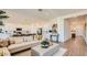 Open-concept living room with a white sofa, leading to the kitchen with modern appliances at 23256 W Tamarisk Ave, Buckeye, AZ 85326