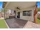 A well-maintained covered back patio with a ceiling fan, roll-down privacy shades, and tile flooring at 2511 W Blue Sky Dr, Phoenix, AZ 85085
