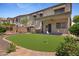 Serene backyard featuring a well-maintained mini golf course and covered patio with custom curtains at 2511 W Blue Sky Dr, Phoenix, AZ 85085