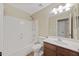 Bright bathroom featuring a shower-tub combination, wood-styled cabinets, and updated vanity at 2511 W Blue Sky Dr, Phoenix, AZ 85085
