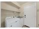 Well-lit laundry room featuring a Maytag washer and dryer, overhead shelving, and a convenient storage area at 2511 W Blue Sky Dr, Phoenix, AZ 85085