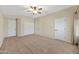 Spacious main bedroom featuring neutral tones, carpet flooring, ceiling fan, and natural light at 2511 W Blue Sky Dr, Phoenix, AZ 85085