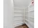 Walk-in pantry with many shelving units for excellent storage and wood-look flooring at 2511 W Blue Sky Dr, Phoenix, AZ 85085