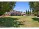 Expansive backyard with lush grass, swimming pool, and covered patio at 2614 E Carob Dr, Gilbert, AZ 85298