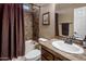Cozy bathroom with tiled shower and tub combo with a single sink vanity at 2614 E Carob Dr, Gilbert, AZ 85298