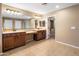 Primary bath with tiled floors, double sinks, vanity, and walk-in closet access at 2614 E Carob Dr, Gilbert, AZ 85298