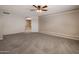 Large, carpeted bedroom featuring a ceiling fan and an arched doorway at 2614 E Carob Dr, Gilbert, AZ 85298