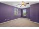 Bedroom with carpet flooring, ceiling fan, and two large windows at 2614 E Carob Dr, Gilbert, AZ 85298