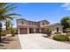 Inviting two-story home showcasing a three-car garage and well-manicured landscaping, enhancing its curb appeal at 2614 E Carob Dr, Gilbert, AZ 85298