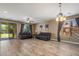 Open-concept living room with wood-look floors and sliding glass door to the backyard at 2614 E Carob Dr, Gilbert, AZ 85298