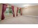 Spacious living room featuring large windows and plush carpeting at 2614 E Carob Dr, Gilbert, AZ 85298