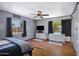Bright bedroom with wood floors, ceiling fan, and two windows with views at 2921 N 103Rd Ave, Avondale, AZ 85392