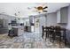 Modern kitchen with stainless steel appliances, gray cabinets, island, and a dining area to the right at 2921 N 103Rd Ave, Avondale, AZ 85392