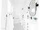 Elegant bathroom with black and white patterned tile floor, white vanity, and oval mirror with sconce lighting at 3330 S Horizon Pl, Chandler, AZ 85248