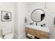 Stylish powder room with a round mirror, a mosaic accent wall, and a wooden vanity with a shelf for storage at 3330 S Horizon Pl, Chandler, AZ 85248