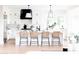 Bright, modern kitchen featuring white cabinetry, an island with wicker stools, and modern pendant lighting at 3330 S Horizon Pl, Chandler, AZ 85248