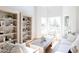 Airy living room features custom bookshelves, white walls, plenty of natural light and hardwood flooring at 3330 S Horizon Pl, Chandler, AZ 85248