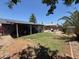 A sprawling backyard features lush green grass, a covered patio, and a charming brick-paved fire pit area at 3615 E Hearn Rd, Phoenix, AZ 85032