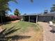 Expansive backyard with covered patio, lush lawn, and vibrant bougainvillea for outdoor enjoyment at 3615 E Hearn Rd, Phoenix, AZ 85032