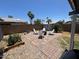 Landscaped backyard featuring a brick-paved patio, a charming fire pit area, and lush greenery for outdoor enjoyment at 3615 E Hearn Rd, Phoenix, AZ 85032