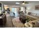 Open-concept living room and kitchen with wood floors, neutral tones, stainless steel appliances, and a large area rug at 3615 E Hearn Rd, Phoenix, AZ 85032