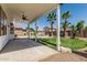 Spacious backyard featuring desert landscaping, mature palm trees, covered patio with fan at 3851 E San Pedro Ave, Gilbert, AZ 85234