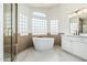 Bright bathroom with standalone tub, glass block windows and a modern vanity at 3851 E San Pedro Ave, Gilbert, AZ 85234