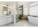 Bright bathroom showcasing a modern vanity, frameless glass shower, and standalone tub at 3851 E San Pedro Ave, Gilbert, AZ 85234