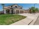 Two-story home features a two-car garage, green lawn, and desert landscaping at 3851 E San Pedro Ave, Gilbert, AZ 85234