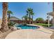 Inviting backyard oasis with a pebble tec pool, waterfall, and swaying palms at 3851 E San Pedro Ave, Gilbert, AZ 85234