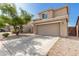 Beige two-story home with concrete driveway and desert landscaping surrounding the property at 3910 W Goldmine Mountain Dr, San Tan Valley, AZ 85144