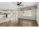 Open living room with wood-look flooring, connecting to the kitchen with a pool view at 3910 W Goldmine Mountain Dr, San Tan Valley, AZ 85144