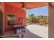Inviting outdoor back patio with ceiling fan, terracotta accent wall and stone pavers at 42022 W Cheyenne Dr, Maricopa, AZ 85138