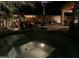 Inviting backyard with spa, palm trees, ambient lighting, and desert landscaping enhances outdoor living at 42022 W Cheyenne Dr, Maricopa, AZ 85138