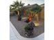 Backyard with desert landscaping, a water feature, and palm trees under evening lighting at 42022 W Cheyenne Dr, Maricopa, AZ 85138