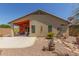 Exterior rear view of home showcasing the covered patio and desert landscaping in the backyard at 42022 W Cheyenne Dr, Maricopa, AZ 85138