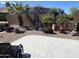 Well-maintained backyard with desert landscaping, tiled patio, and mature palm trees at 42022 W Cheyenne Dr, Maricopa, AZ 85138