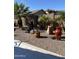 Well-manicured desert landscaping with water feature and mature palm trees in the backyard at 42022 W Cheyenne Dr, Maricopa, AZ 85138
