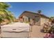 Backyard view with hot tub, gravel, and desert plants under a clear blue sky at 42022 W Cheyenne Dr, Maricopa, AZ 85138