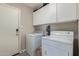 Bright laundry room features white cabinetry, a washer and dryer, and ample storage space at 42022 W Cheyenne Dr, Maricopa, AZ 85138