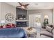 Inviting living room featuring a modern fireplace, ceiling fan, and comfortable seating at 42022 W Cheyenne Dr, Maricopa, AZ 85138