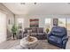 Bright and airy living area showcasing a comfortable sofa, accent chair, and ambient lighting at 42022 W Cheyenne Dr, Maricopa, AZ 85138