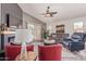 Bright living area with vaulted ceiling, fireplace, ceiling fan, and backyard access at 42022 W Cheyenne Dr, Maricopa, AZ 85138