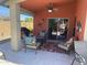 Covered patio features ceiling fan, comfortable seating, and outdoor dining area overlooking backyard at 42022 W Cheyenne Dr, Maricopa, AZ 85138