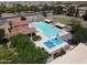 Aerial shot of a community pool, pool house, splash pad, lounge chairs, and picnic area at 42022 W Cheyenne Dr, Maricopa, AZ 85138