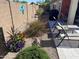 Landscaped side yard with lush flowers, cacti, pavers, grill, and outdoor dining set at 42022 W Cheyenne Dr, Maricopa, AZ 85138