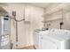 Functional laundry area with washer, dryer, water heater, and storage shelves at 4648 N 40Th St, Phoenix, AZ 85018