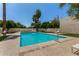 A sparkling blue pool surrounded by mature trees and well-maintained landscaping provides a serene atmosphere at 4648 N 40Th St, Phoenix, AZ 85018