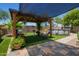 Backyard with a gazebo, patio seating, artificial grass, an above ground pool and shade at 518 S 114Th Ave, Avondale, AZ 85323